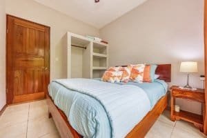 Comfortable bedroom with wooden furniture and soft bedding in a tropical villa.