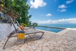 Relaxing pool with ocean view and lounge chairs in Dominical, Costa Rica.
