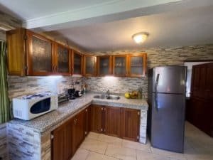 Modern kitchen in Costa Rica with wooden cabinets and stainless steel refrigerator.