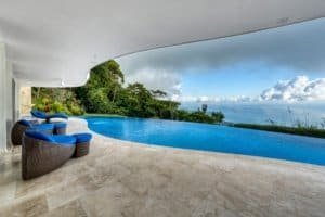 Modern infinity pool overlooking lush jungle and ocean in Costa Rica.