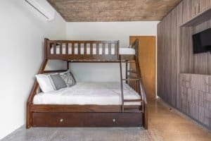 Bedroom with wooden bunk bed and modern decor in Dominical real estate.