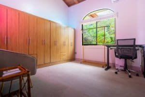 Bright home office with large window and wooden cabinets in Dominical.