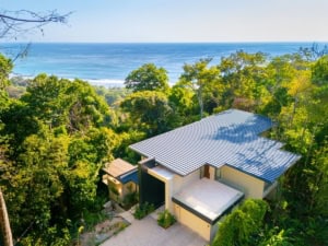 Modern tropical home with ocean view, surrounded by lush greenery in Dominical.