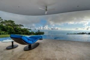 Modern outdoor deck with ocean view, lounge chair, and ceiling fan in Dominical.