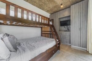 Contemporary bedroom with wooden bunk bed and TV in Dominical Costa Rica.
