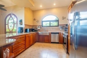 Bright kitchen with wooden cabinets, stainless steel appliances, and ocean view window.