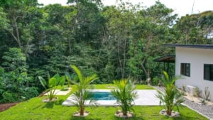 Beautiful Costa Rican property with pool, lush garden, and forest view.