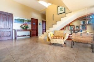 Spacious living room with staircase, bookshelf, and armchair in Costa Rica.