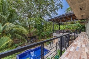 Balcony overlooking lush tropical forest and pool in Dominical, Costa Rica.