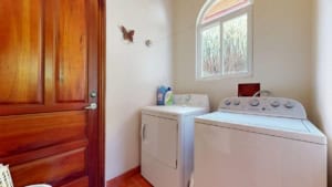 Laundry room with washer, dryer, and mountain view window in Dominical.