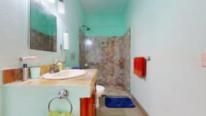 Small bathroom with shower, sink, and colorful towels in Dominical.