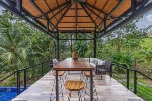 Balcony with dining table and lush tropical greenery in Dominical, Costa Rica.
