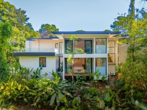 Modern tropical home with ocean view, surrounded by lush greenery in Dominical.