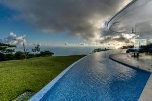 Modern infinity pool overlooking lush landscape and ocean in Costa Rica.