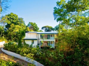 Modern tropical home with ocean view, surrounded by lush greenery in Dominical.