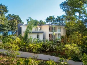 Modern tropical home with ocean view, surrounded by lush greenery in Dominical.