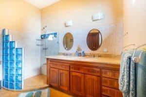 Bathroom with double vanity, mirror, and walk-in shower in Costa Rica.