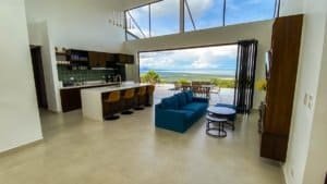 Bright living room with panoramic ocean and mountain views in Dominical, Costa Rica.