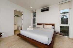 Modern bedroom with ocean view, white walls, and minimalist decor in Costa Rica.