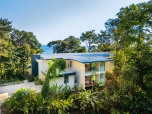 Modern tropical home with ocean view, surrounded by lush greenery in Dominical.