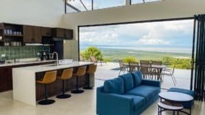 Modern interior with panoramic ocean and mountain view from living room.