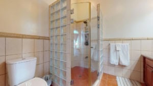 Modern bathroom with glass shower, toilet, and towel rack in Costa Rica.