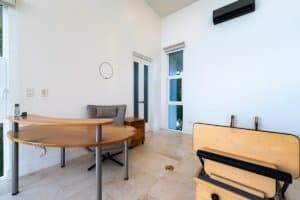 Bright modern room with desk, piano, and balcony view.