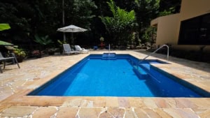 Luxury pool with waterfall and lush tropical surroundings in Costa Rica.