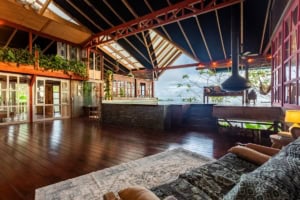 Spacious interior with high ceilings, wood floors, and ocean view in Dominical.