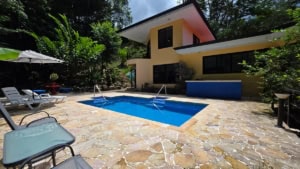 Modern home with pool, waterfall, and lush tropical surroundings in Dominical.