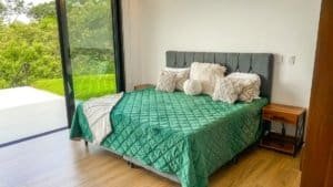 Modern bedroom with panoramic ocean and mountain views in Dominical.