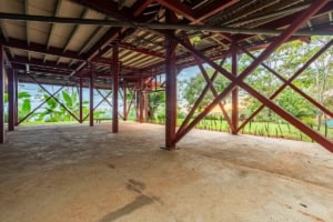 Underneath elevated structure with ocean view and lush greenery.
