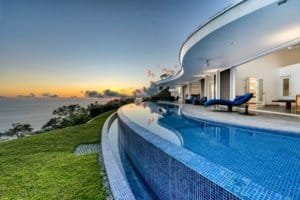 Modern villa with infinity pool overlooking the ocean at sunset in Costa Rica.