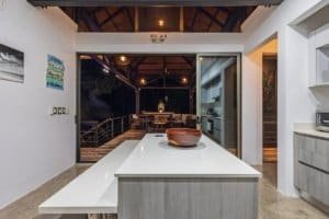 Contemporary kitchen opening to outdoor dining area in Dominical Costa Rica.