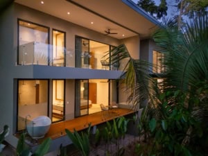 Modern Costa Rican home with ocean views, balcony, and lush garden surroundings.