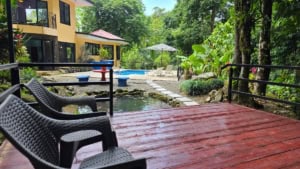 Outdoor pool area with deck, chairs, and lush greenery in Dominical.