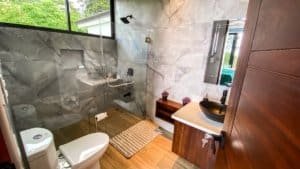 Modern bathroom with marble walls and mountain view window.