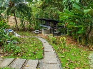 Lush tropical garden with pathway and outdoor seating in Dominical, Costa Rica.