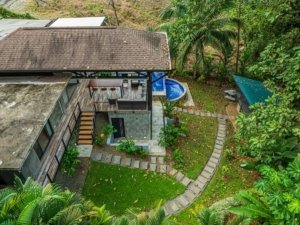 Aerial view of a tropical home with lush garden and pool in Dominical.