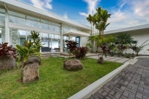 Contemporary Costa Rican estate with lush garden and palm trees.