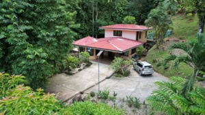 Charming Costa Rican home with pool, waterfall, surrounded by lush greenery.