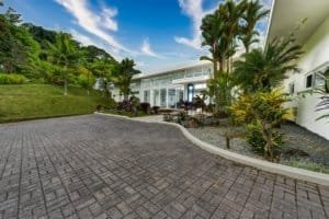 Modern estate with lush tropical landscaping and paved driveway in Dominical.