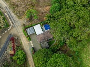 Aerial view of a property in Dominical surrounded by lush greenery and trees.