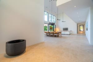 Spacious open-plan living area with large windows and minimalist decor.