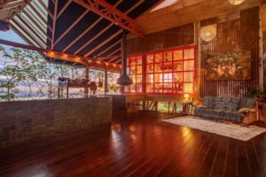 Interior of a Costa Rican ocean view home with wooden floors and large windows.