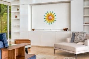 Bright living room with sun-shaped wall art and large window view.