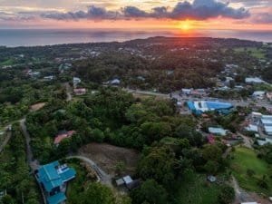 Scenic sunset over Dominical with lush greenery and residential area.