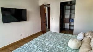 Spacious bedroom with a large bed and mountain view in Dominical, Costa Rica.