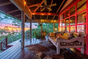 Covered deck with cozy seating and sunset view in Dominical, Costa Rica.