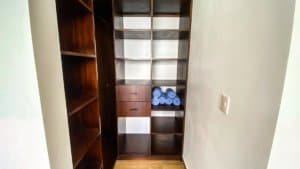 Interior view of a wooden closet with shelves and rolled towels in Dominical, Costa Rica.